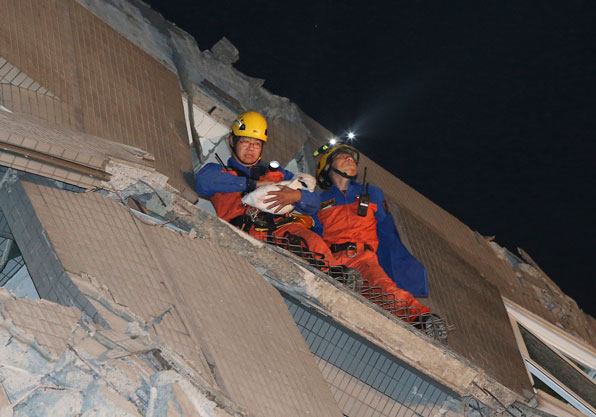 ▶ 무너진 건물 안에서 아기를 구출하는 구조대 (사진: AP)
