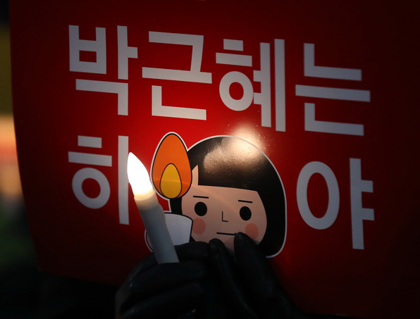 박근혜 대통령 퇴진촉구 촛불집회가 열린 11월 26일 오후 서울시 종로구 청운동주민센터 앞에서 한 집회 참가자가 LED 촛불과 피켓을 들고 있다.