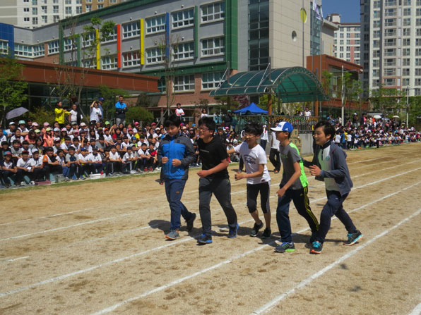 달산초 6학년 학생들이 달리기 시합 중 넘어진 친구를 부축해 함께 결승선을 향하고 있다.