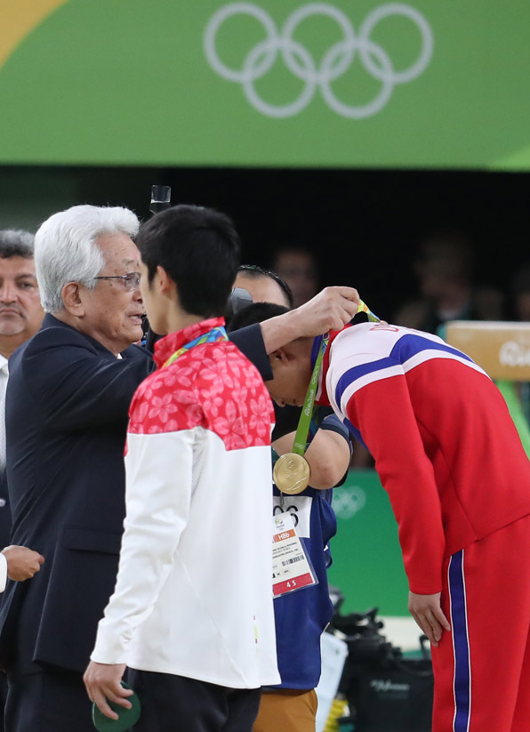15일(현지시간) 오후 브라질 리우데자네이루 리우 올림픽 경기장에서 열린 남자 기계체조 도마 결선이 끝난 뒤 열린 시상식에서 북한 장웅 IOC  위원이 리세광에게 금메달을 수여하고 있다.