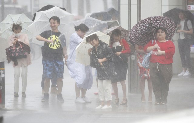 4일(현지시간) 일본 도쿄, 시코쿠 등의 시민들이 우산을 쓰고 횡단보도를 건더고 있지만, 불어오는 강풍과 폭우에 고개를 들지 못하고 있다. [사진출처 : AP=연합뉴스]