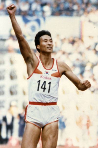 1986년 서울 아시안게임 남자 육상 200m에서 우승한 뒤 오른손을 번쩍 들어 1위의 기쁨을 표현하고 있는 장재근(사진: 스포츠동아)