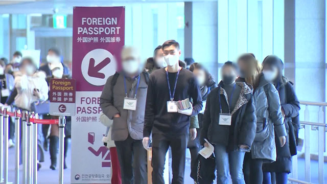 여권을 든 인솔자가 앞장 선 가운데, 중국발 여객기 승객들이 줄지어 들어오고 있다.
