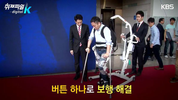 2014년 의료박람회에서 송인수 씨가 의료용 로봇을 입고 걷고 있다.