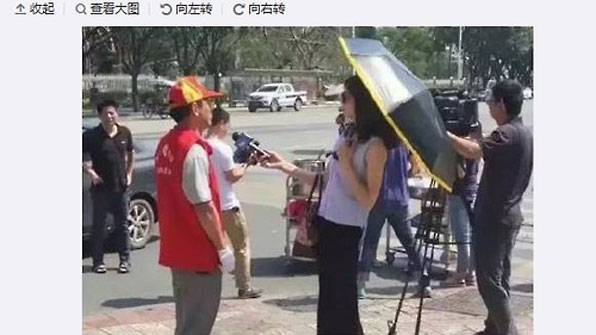 선글라스와 양산을 쓰고 취재하는 중국 여기자 (웨이보 캡처)