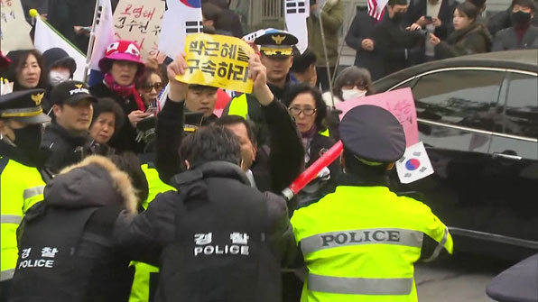 박근혜 전 대통령에 대한 구속 수사를 촉구하다 경찰에 둘러싸인 시민