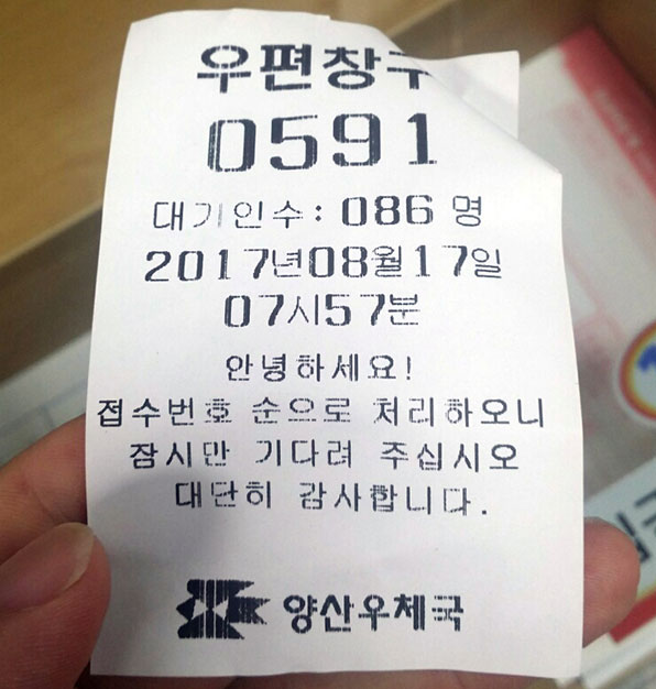 이른 시각, 경남 양산우체국에서 한 시민이 문재인 대통령 취임 기념 우표를 구매하기 위해 받은 591번 대기 번호표를 보여주고 있다.