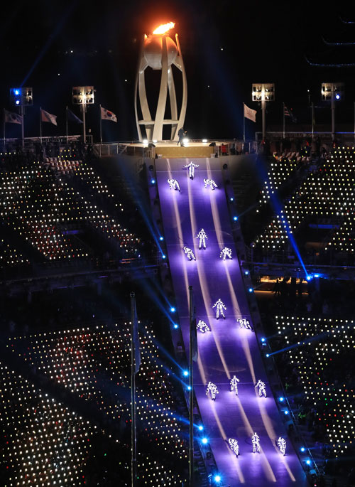 25일 강원도 평창 올림픽스타디움에서 열린 2018평창동계올림픽 폐회식에서 출연진들이 성화대로 향하는 경사면에서 조화의 빛 공연을 펼치고 있다. 