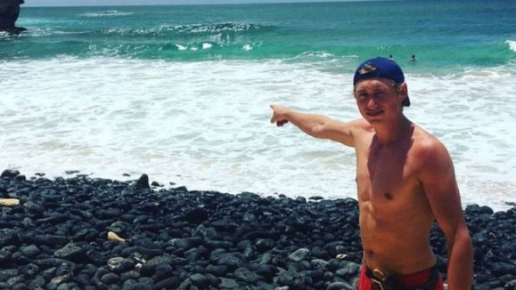 맥 윌리엄스가 하와이 카우아이 섬 해변에서 자신이 상어 공격을 받은 지점을 손으로 가리키고 있다. [사진 캡처= BBC 홈페이지]