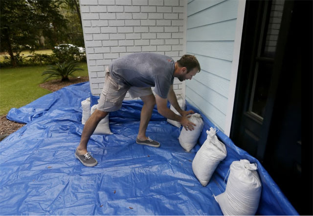 집안으로 빗물이 들어가는 것을 방지하기 위해 한 주민이 작업 중이다. 사우스캐롤라이나 주