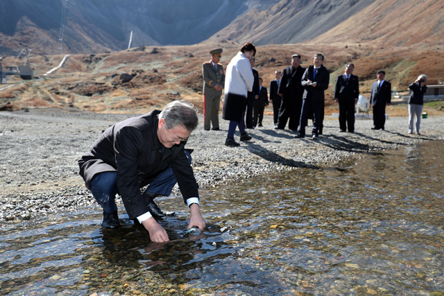 문재인 대통령이 20일 오전 김정은 국무위원장 내외와 백두산 천지를 산책하던 중 천지 물을 물병에 담고 있다.