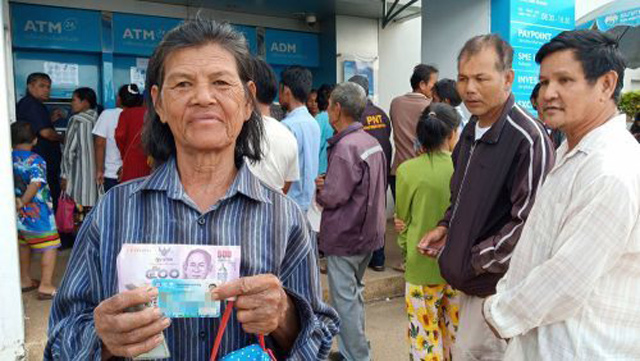 현금지급기 앞에서 500밧을 찾고 기념사진을 찍는 모습 (출처: Khaosod)