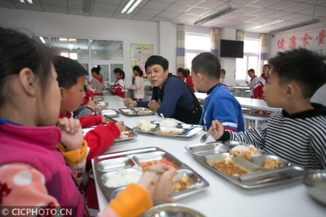 베이징의 한 학교 교장이 아이들과 같이 급식을 먹고 있다. 2019.4.1