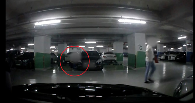 대리기사(빨간 원)이 손님의 차량 밑에 지갑을 숨기는 장면(경기남부지방경찰청 제공) 