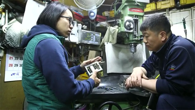 송호준 작가(왼쪽)가 정밀기계 공장을 방문해 정연정 사장과 인공위성의 개선할 점을 논의하는 모습.