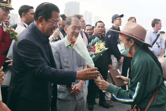 훈센 캄보디아 총리가 13일 시나우크빌항에 입항한 ‘웨스테르담’ 승무원에게 꽃다발을 건네고 있다.