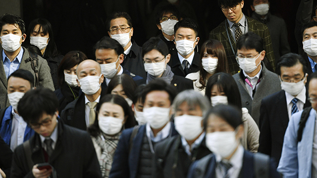 고이케 지사가 ‘재택근무’를 촉구한 다음 날인 26일 도쿄에서 마스크를 쓴 직장인들이 출근하고 있다. (교도=연합)