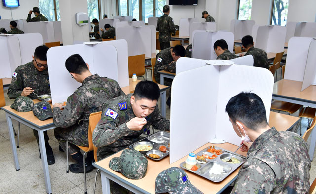 공군 11전투비행단 장병들이 종이가림막을 설치한 테이블에서 점심식사를 하고 있다.