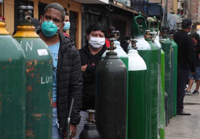 지난 3일 페루 칼라오에서 마스크를 쓴 시민들이 빈 산소통에 산소를 채우기 위해 가게 앞에 줄을 서 있다. [AP=연합]