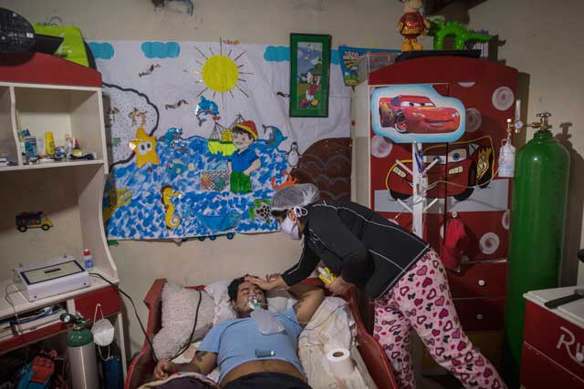 페루 리마의 한 가정에서 아내가 코로나19에 감염된 남편을 산소 호흡기 등을 이용해 간호하고 있다. [AP=연합]
