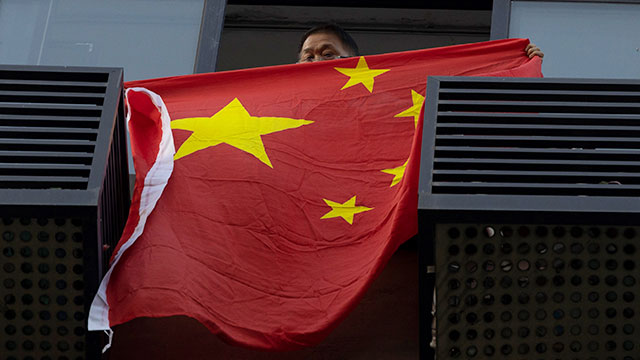 지난 26일 청두 미 영사관 맞은편 건물 발코니에서 한 중국인 남성이 중국 국기를 내걸고 구호를 외치고 있다. [사진=AP 연합뉴스]