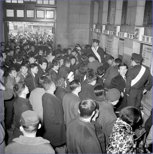 ▲음력설을 맞아 고향을 찾기 위해 기차역 매표소를 가득 채운 사람들의 모습(1968년).
