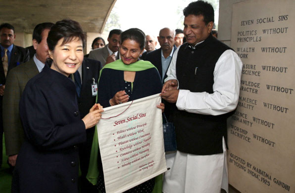 2014년 1월 박근혜 대통령이 마하트마 간디 추모공원을 방문해 관계자들로부터 간디가 제시한 7대 사회악이 새겨진 깃발을 선물로 받고 있다.