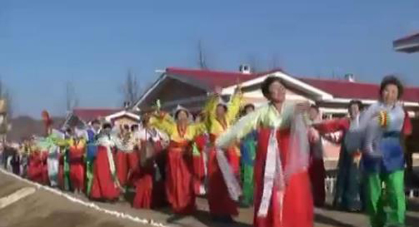 한복을 곱게 차려입은 주민들이 살림집 입주를 축하하며 춤을 추고 있다.