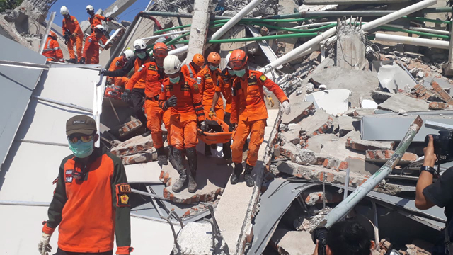 팔루 시내 8층짜리 로아로아 호텔의 건물 잔해에서 구조대원들이 희생자를 수습해 옮기는 모습(출처:로이터=연합뉴스)