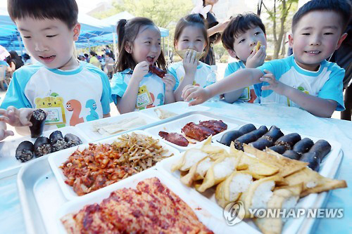 통일부가 주최한 '통일박람회' 북한음식 체험행사에서 어린이들이 인조고기 밥 등 북한 음식을 맛보고 있다. (2015년 8월)