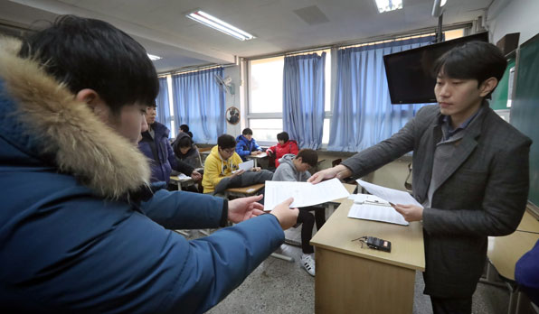 서울의 한 고등학교에서 3학년 학생들이 선생님으로부터 수능 성적표를 전달받고 있다.