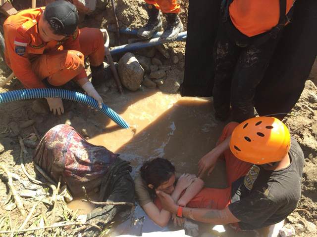팔루에서 구조대원들이 물로 흥건한 잔해 속에서 한 여성을 구조하는 모습(출처:AP=연합뉴스)