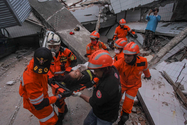 지진으로 붕괴된 레스토랑 잔해에 갇혀있던 생존자를 구조대원들이 구조해 후송하고 있다.(출처:   Antara Foto/Muhammad Adimaja/ via REUTERS)