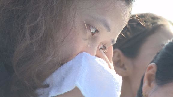 푸미폰 왕의 사진을 들여다보며 눈물을 흘리고 있는 태국 여성