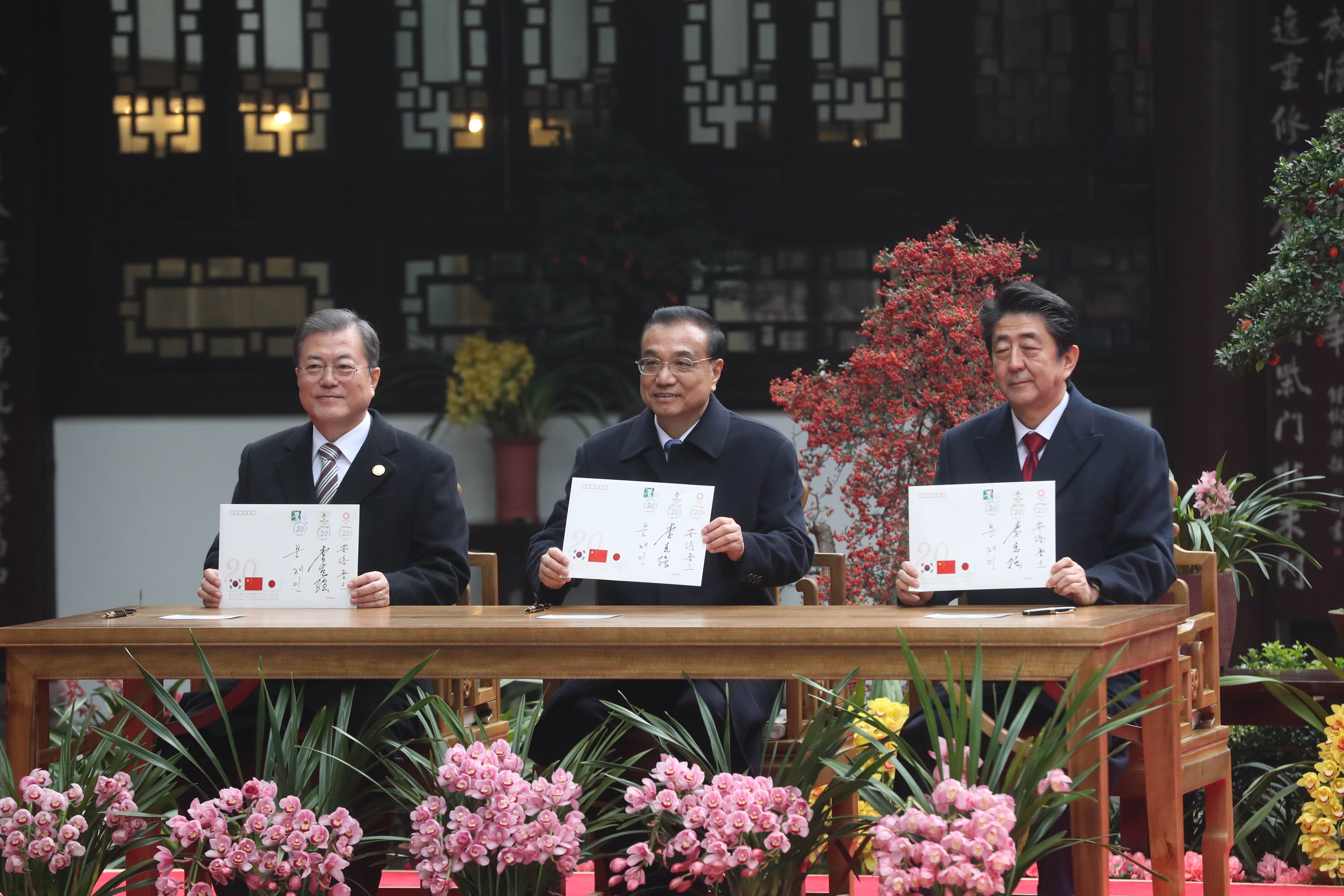 문재인 대통령과 리커창 중국 총리, 아베 일본 총리가 지난해 12월 24일 중국 쓰촨성 청두에서 한·중·일 정상회의를 개최한 뒤 두보초당을 찾아 한·중·일 협력 20주년 기념 봉투에 서명한 후 기념촬영 하고 있다.