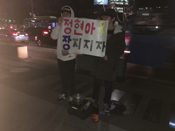 탄핵안이 가결된 9일 오후 광화문 광장에서 두 청년이 ‘정현아 장 지지자’라는 손팻말을 들고 있다.