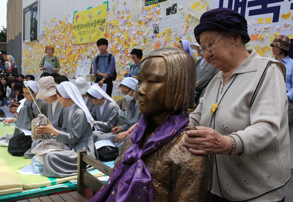 지난 6월 8일 서울 주한일본대사관 앞 소녀상 주변에서 열린 1234차 수요집회에서 위안부 피해자 길원옥 할머니가 소녀상을 어루만지고 있다.