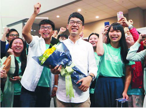 홍콩 입법회 의원 사상 최연소 의원이 된 23살의 네이선 로가 활짝 웃고 있다. 네이선 로의 왼쪽 옆은 2014년 17세의 나이로 우산 혁명을 함께 이끈 조슈야 웡 (사진=AP)
