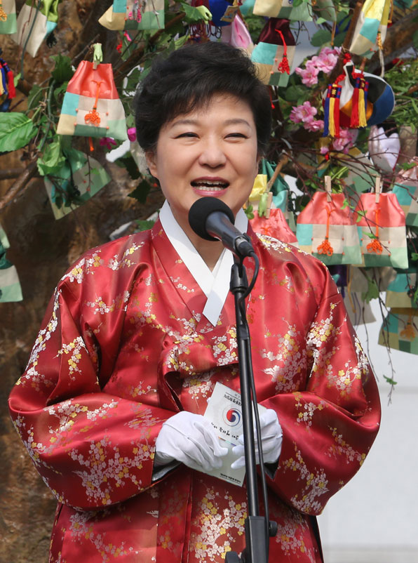 한복을 입은 박근혜 대통령이 취임식을 마치고 청와대로 향하다 광화문 광장에서 열린 '희망의 열리는 나무'에 참석해 국민들의 희망이 적힌 복주머니(오방낭) 속 글을 읽고 있다. (2013.2.25) 