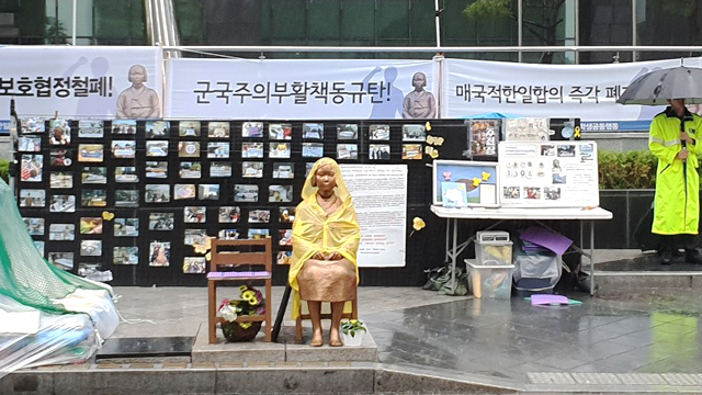 26일 오전 서울 종로구 옛 일본대사관 터 앞에 소녀상이 우비를 입고 앉아 있다.