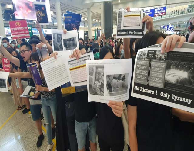 지난 7월 26일, 공항 입국장에서 홍콩 시위대가 외국인 관광객을 상대로 홍보하고 있다.