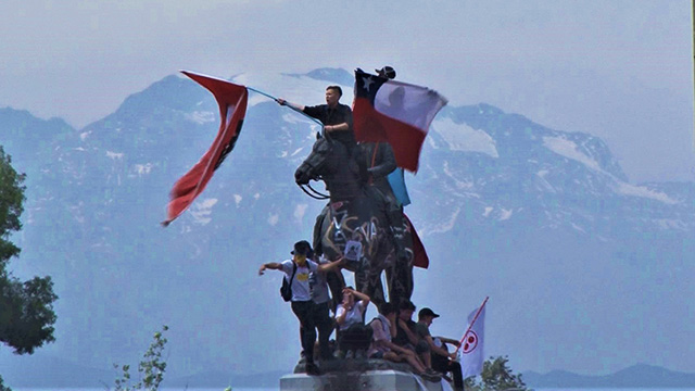 광장 동상 위에서 국기 흔드는 시위대