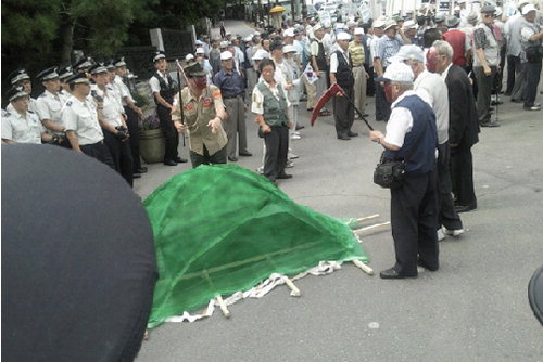 2009년 9월 국립현충원 정문 앞에서 어버이연합 회원들이 김대중 전 대통령 묘를 파헤치는 퍼포먼스를 보였다. [사진 제공] 블로그 ‘미디어 몽구’