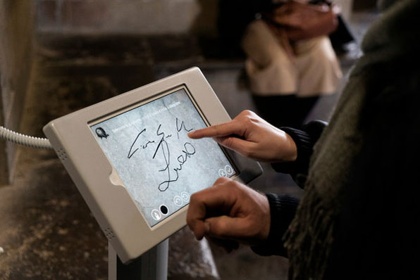 한 관광객이 태블릿 PC에 낙서를 하고 있다. [사진=뉴욕타임스]