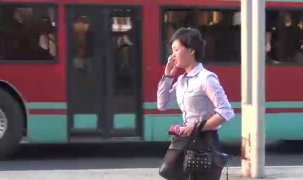 한 여성이 휴대폰을 이용해 전화를 하며 바삐 걸어가고 있다. 평양에서 휴대폰 사용은 일상화됐다.