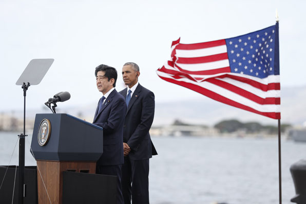 아베 신조 일본 총리가 애리조나기념관이 바라보이는 킬로 피어에서 메시지를 발표하고 있다. 버락 오바마 대통령이 이를 지켜보고 있다. (사진=AP)
