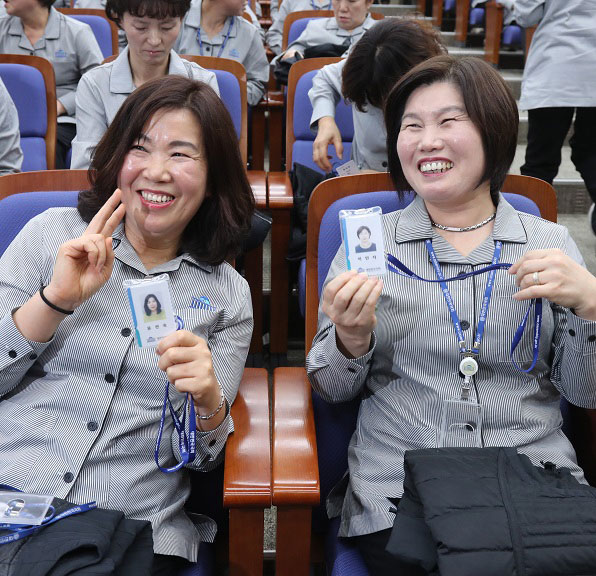 국회 출입증이 아닌 국회 직원 신분증을 받고 활짝 웃으며 기뻐하는 근로자들