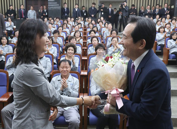 근로자 대표에게 국회 직원 신분증을 전달한 뒤 감사의 꽃다발을 받는 정세균 국회의장