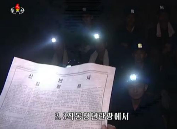  2.8직동청년탄광에서 석탄을 채굴하는 광부들이 김정은 신년사를 읽고 있다. 광부들은 탄광 안이 어두워 핼멧에 부착된 전등을 이용해 신년사를 학습하고 있다. 