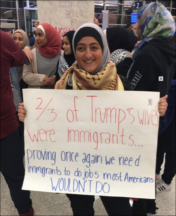 “트럼프 부인 중 3분의 2가 이민자였다. 대다수 미국인이 꺼리는 일을 하는 이민자들이 필요하다는 것을 다시 한 번 증명한다.”는 글을 들고 있는 이슬람 여성의 모습